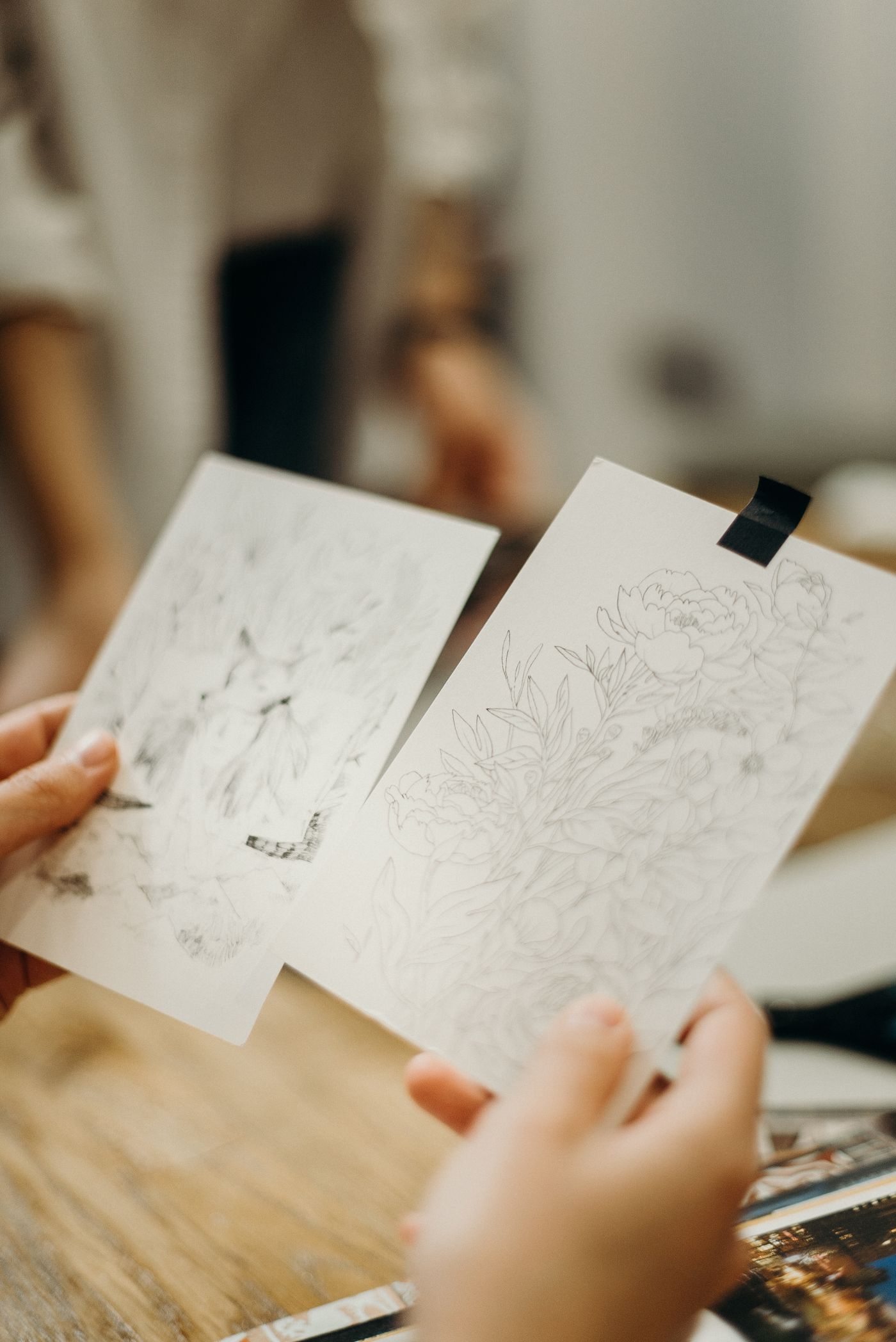 A creator inspecting original drawings on loose sheets.