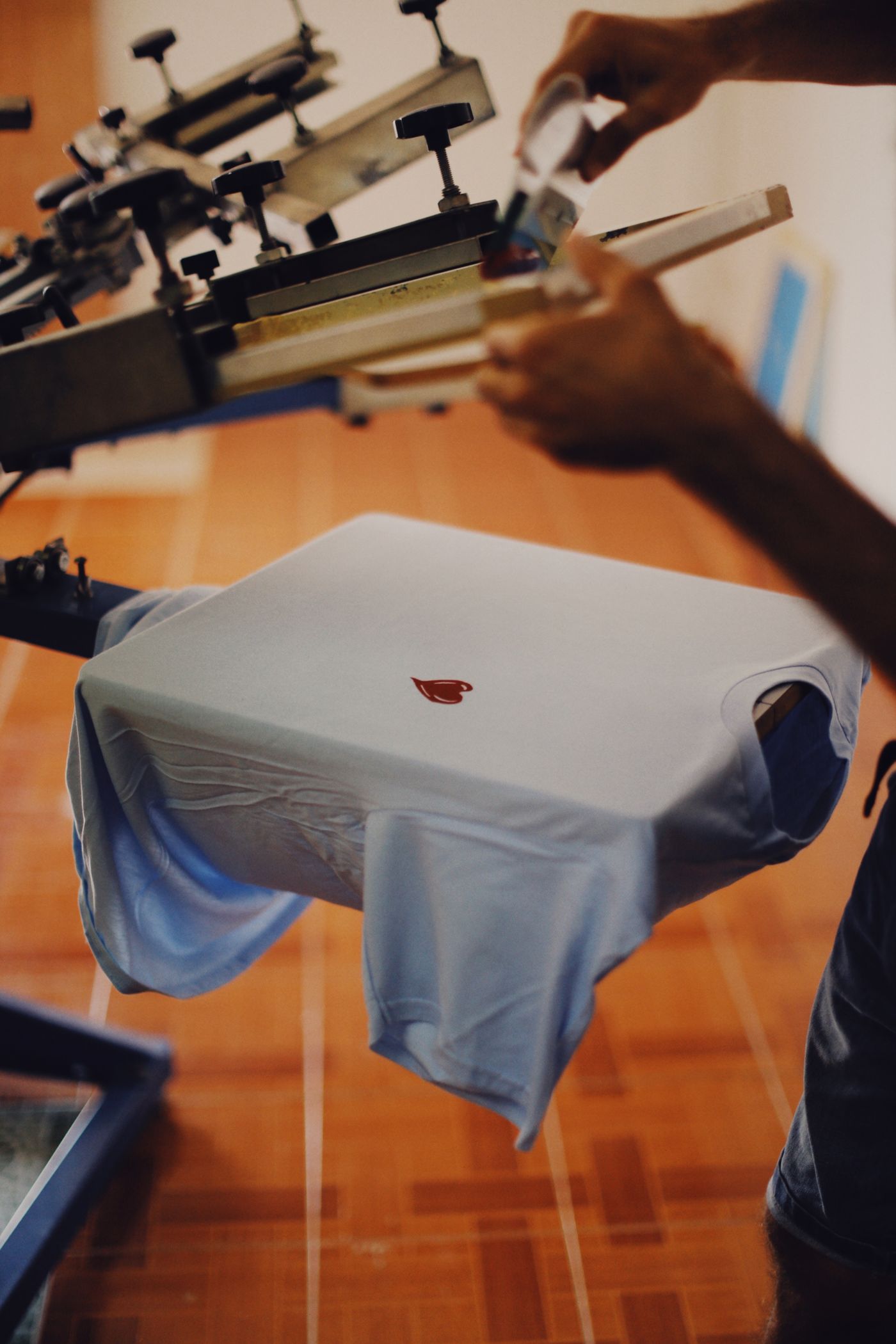 A person screen printing a design onto a T-shirt.