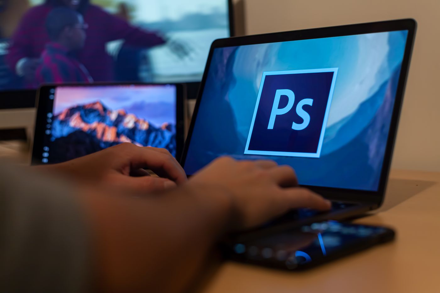 A person working with Photoshop on a laptop.